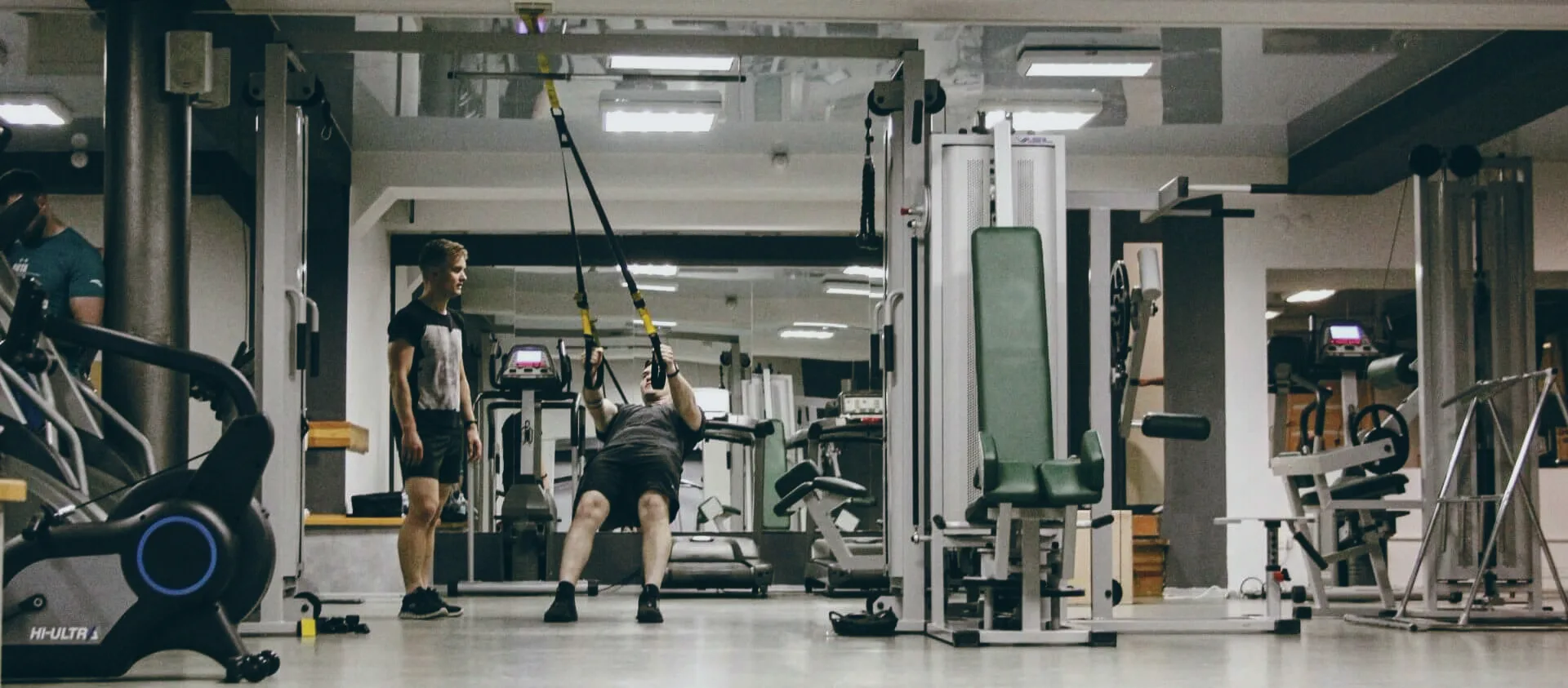 Персональне тренування у FitMe — тренер поруч із клієнтом на TRX